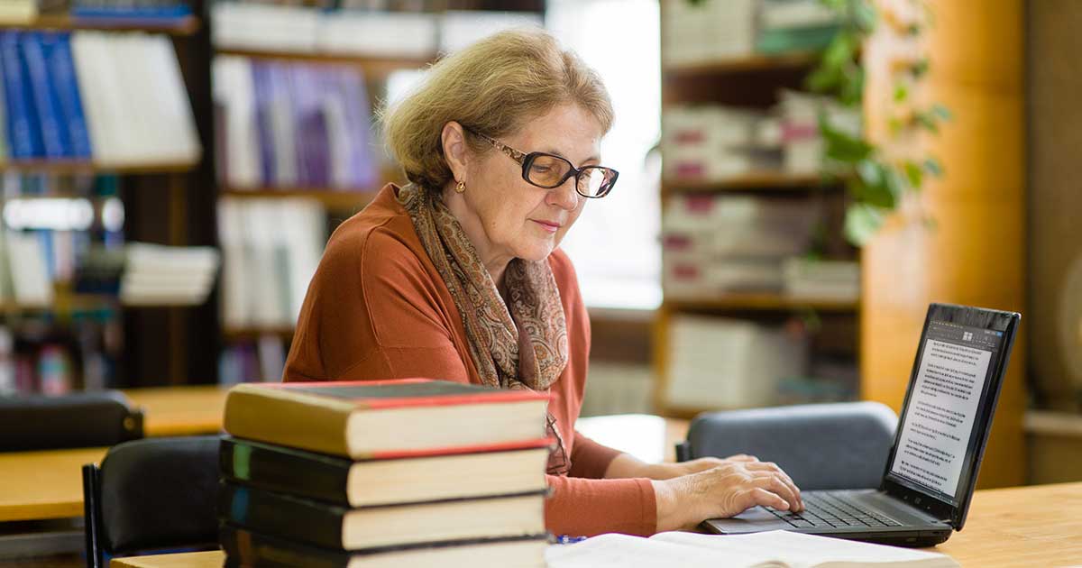 A woman at the library working on her laptop.