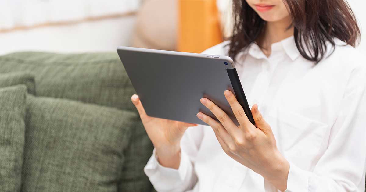 A person holding up a tablet.