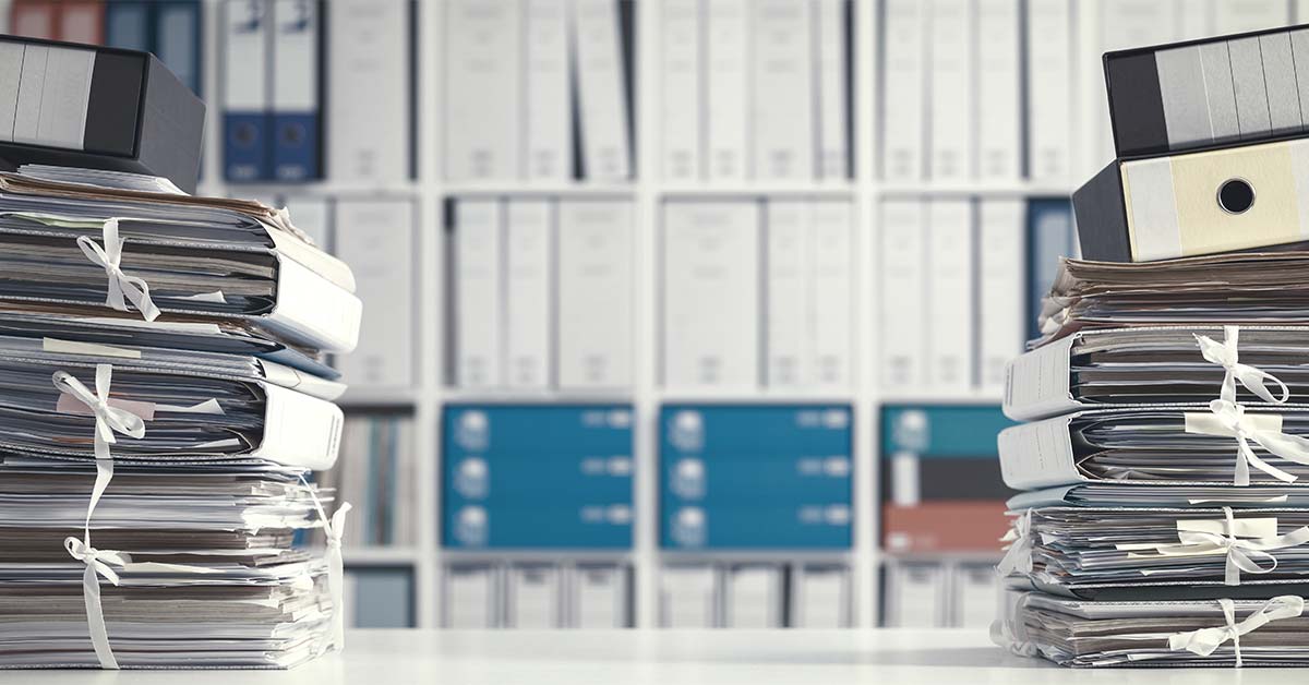 Stacks of physical records, representing the challenges of managing corporate archives.