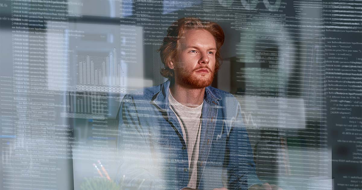 Person at a laptop pauses to think, with layers of code and data charts overlaid across the image.